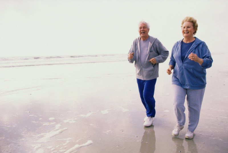 Elderly couple running on beach